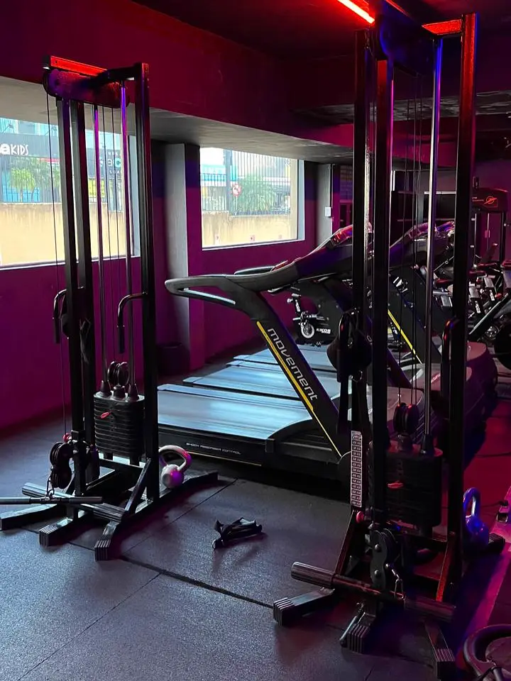 Aparelhos de musculação sob luz vermelha e roxa
